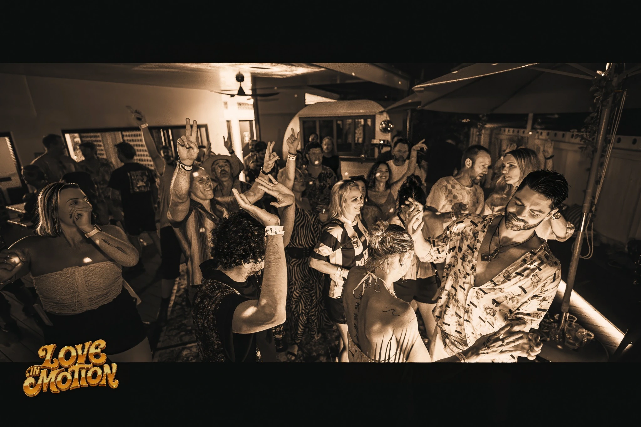 Sepia photograph of the crowd dancing together at Gathering 001