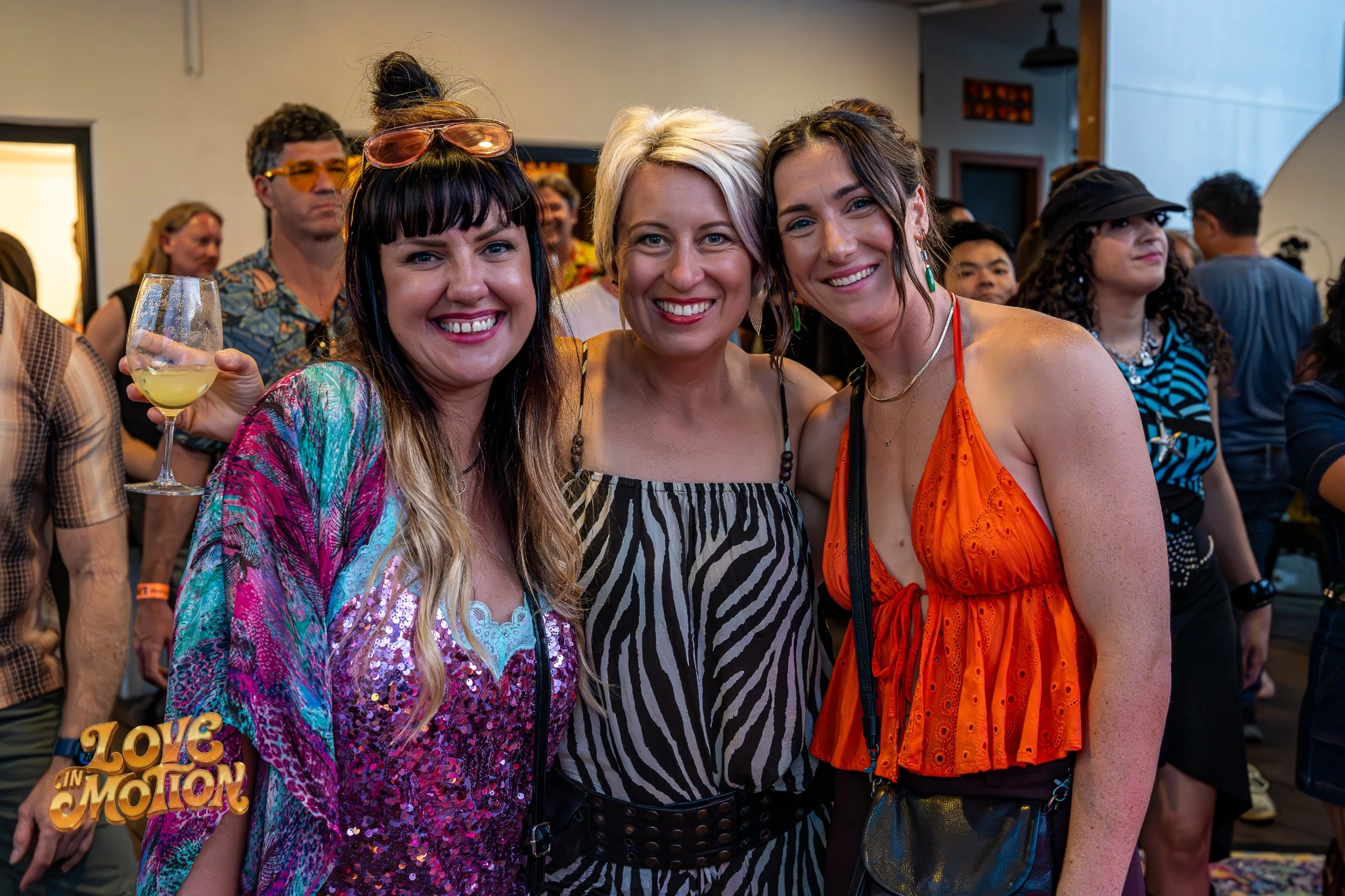 Three smiling friends together at Love in Motion
